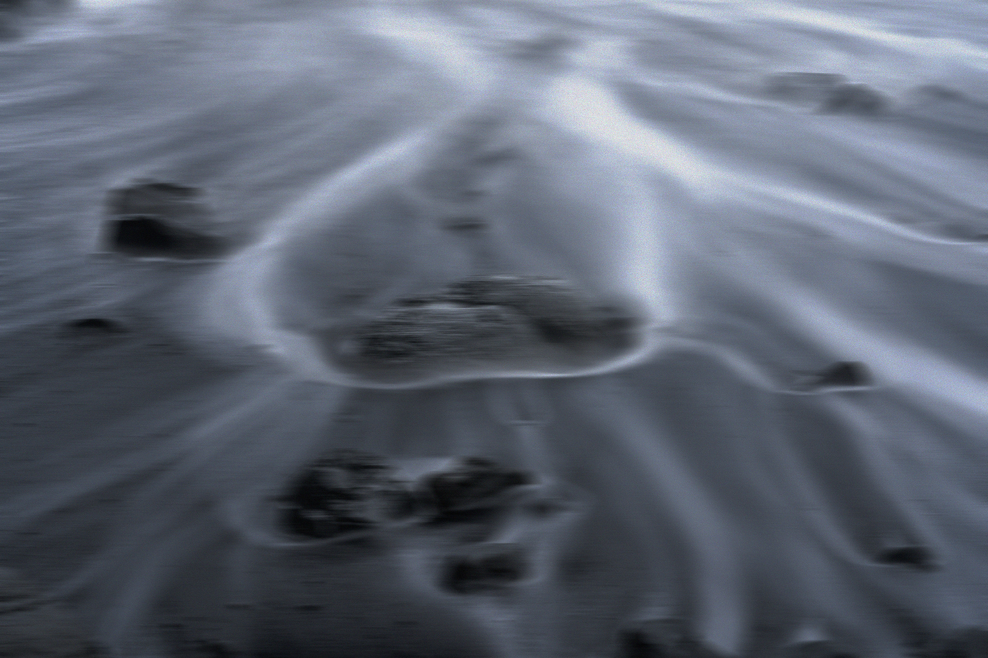 Water flowing over sand and stones in motion blur